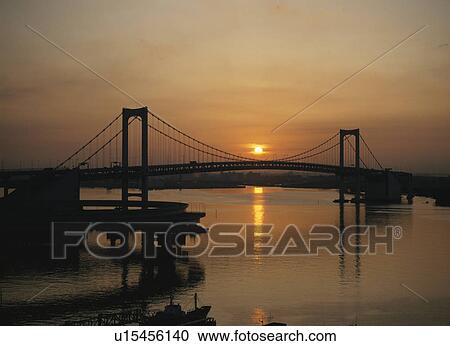 Stock Image - Rainbow Bridge And The Morning Sun In Tokyo. Fotosearch