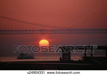 Stock Image - Sun Setting Under Bridge. Fotosearch