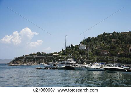 Stock Photo - Boats in marina next to coastal villa.. Fotosearch
