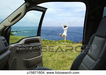 Excited woman standing on grassy cliff by Pacific Ocean in Maui, Hawaii. View Large Photo Image Picture - Excited woman standing on grassy cliff by Pacific Ocean in Maui, Hawaii.. Fotosearch
