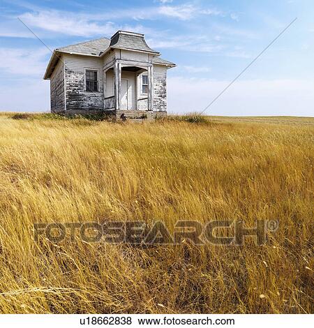 Stock Photo - Weathered abandoned building in remote grassland.. Fotosearch