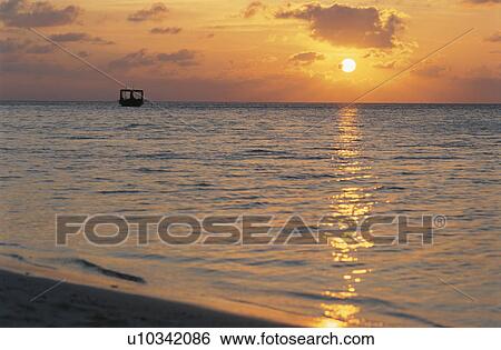 Stock Photograph - The Setting Sun And The Sea. Fotosearch