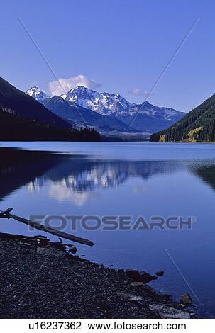 Stock Image - The mountains above Carpenter Lake are reflected in early winter, BC. Fotosearch