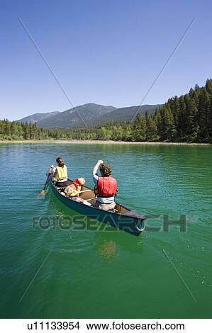 Young family canoeing on Loon Lake in the East Kootenays, British Columbia, Canada View Large Photo Image Picture - Young family canoeing on Loon Lake in the East Kootenays, British Columbia, Canada. Fotosearch