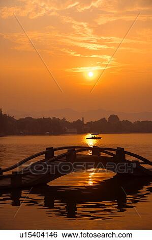 Stock Photograph - Causeway in the sunset in West Lake, Hangzhou, Zhejiang Province. Fotosearch