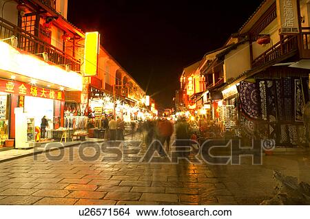 Picture - China, Guangxi Province, Guilin, Yangshuo, people on the illuminating Yangshuo West Street, at night. Fotosearch
