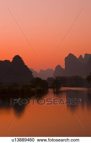 China, Guangxi Province, Guilin, Yangshuo, Yulong River with mountains at sunset View Large Photo Image Stock Image - China, Guangxi Province, Guilin, Yangshuo, Yulong River with mountains at sunset. Fotosearch
