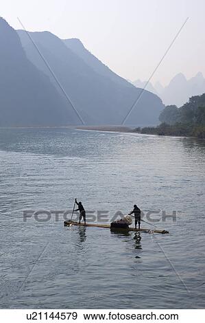Stock Photo - China, Guangxi Province, Guilin, Yangshuo, two people on wooden raft. Fotosearch