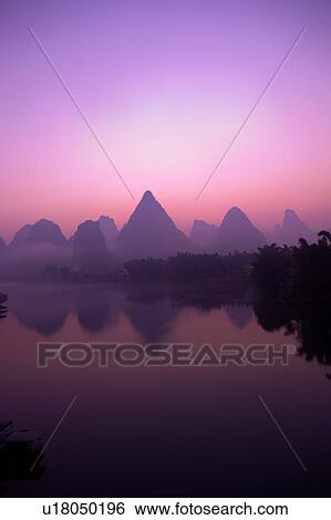 Stock Photograph - China, Guangxi Province, Guilin, Yangshuo, Li River and mountain at sunrise. Fotosearch