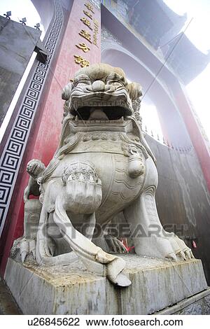 Stock Image - Stone lion in front of memorial archway. Fotosearch