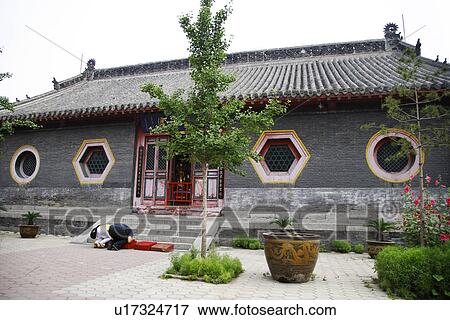 Stock Photo - China, Liaoning Province, Shenyang, Person praying in Ci'en Temple. Fotosearch