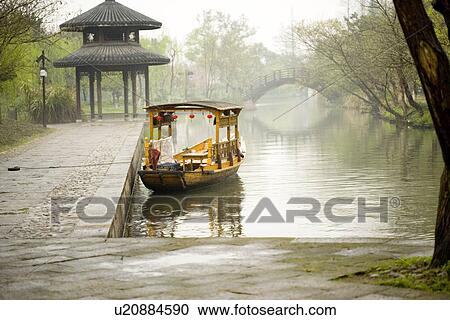Stock Image - China, Zhejiang Province, Hangzhou, boat on the West Lake. Fotosearch
