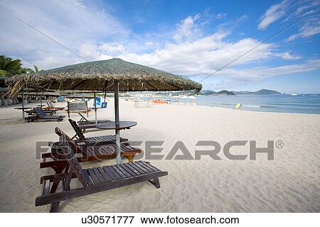 Stock Photo - Beach chairs and umbrellas on beach, Yalong Bay, Hainan Province. Fotosearch