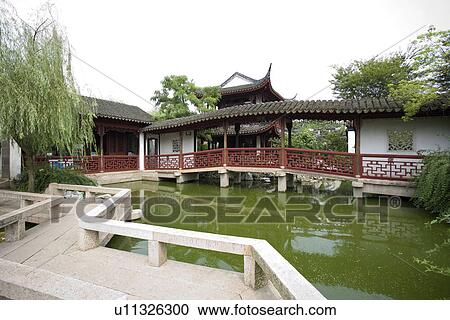Stock Image - Asia, China, Jiangsu Province, Tongli Town, Zigzag bridge in garden. Fotosearch