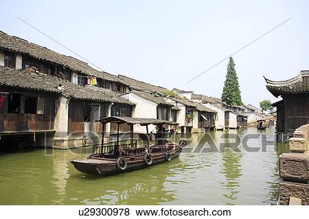 Stock Photo - Asia, China, Zhejiang Province, Wuzhen, Rowing boat in water town. Fotosearch