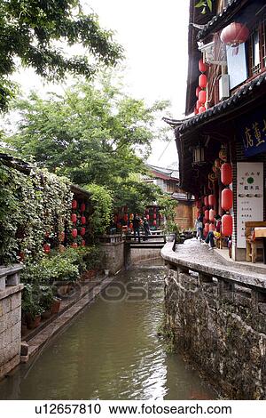Stock Image - China, Yunnan Province, Ancient Scenic Town, house along canal. Fotosearch