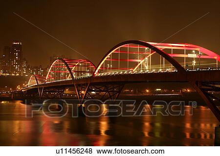 Stock Photo - Night view of bridge upon river, illuminated. Fotosearch
