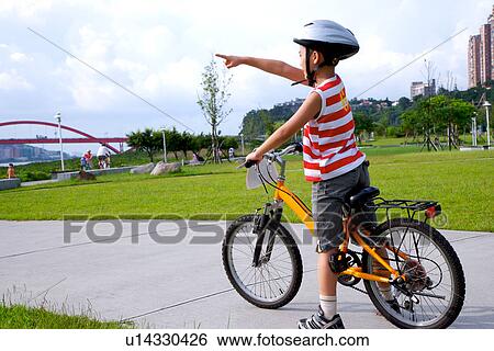 Stock Photograph - Boy with bicycle in park. Fotosearch