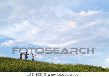 Three persons holding hands standing on grass, rear view View Large Photo Image Stock Image - Three persons holding hands standing on grass, rear view. Fotosearch