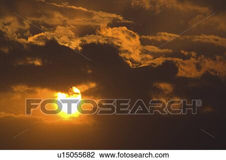 Stock Image - China, Yunnan Province, Dongchuan, Red Land, Sun behind clouds. Fotosearch