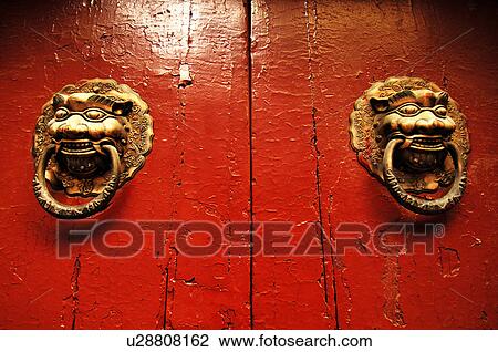 Stock Image - Two traditional Chinese door knockers in shape of lion head, Beijing, China. Fotosearch
