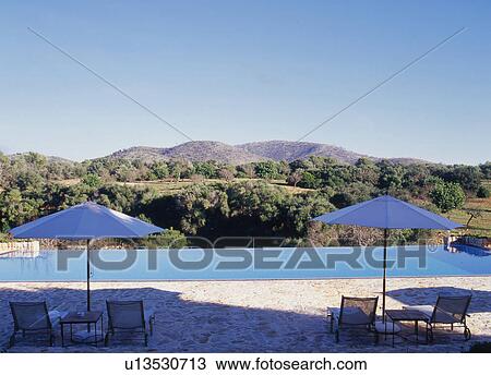 Stock Image - Deckchairs beside the pool. Fotosearch