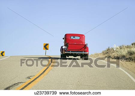 A restored bright Red pickup truck, mid-30's, drives rural highway in Kern County near Lockwood Valley, CA View Large Photo Image Stock Photo - A restored bright Red pickup truck, mid-30's, drives rural highway in Kern County near Lockwood Valley, CA. Fotosearch