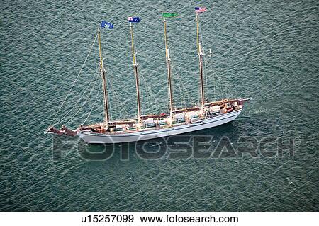 Stock Photo - A tall ship with sails down cruises in bay outside of Acadia National Park, ME. Fotosearch