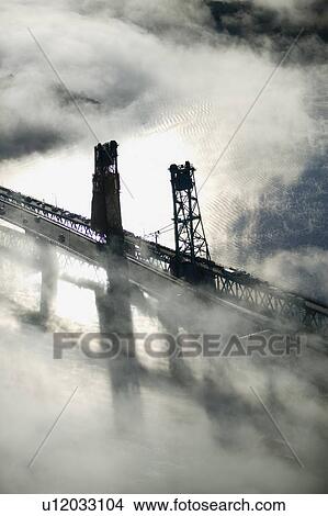 Aerial view of fog over Bath Iron Works and Kennebec River in Maine. Bath Iron Works is a leader in surface combatant design and construction with a $27 million dollar contract from the Navy for maintenance, repair and upgrades to Aegis destroyers. View Large Photo Image Picture - Aerial view of fog over Bath Iron Works and Kennebec River in Maine. Bath Iron Works is a leader in surface combatant design and construction with a $27 million dollar contract from the Navy for maintenance, repair and upgrades to Aegis destroyers.. Fotosearch