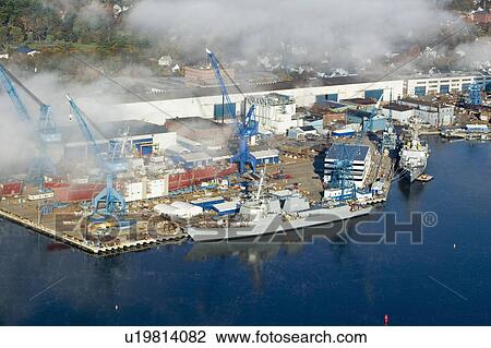Stock Image - Aerial view of fog over Bath Iron Works and Kennebec River in Maine. Bath Iron Works is a leader in surface combatant design and construction with a $27 million dollar contract from the Navy for maintenance, repair and upgrades to Aegis destroyers.. Fotosearch