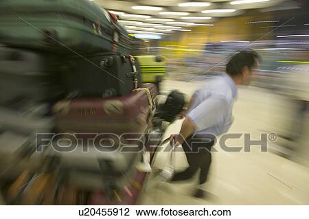Baggage man pulls luggage at Madrid Barajas Airport (MAD), Spain's busiest airport View Large Photo Image Stock Image - Baggage man pulls luggage at Madrid Barajas Airport (MAD), Spain's busiest airport. Fotosearch