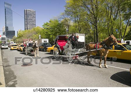 Stock Photography - Horse and carriage drives in traffic down Central Park West in Manhattan, New York City, NY. Fotosearch