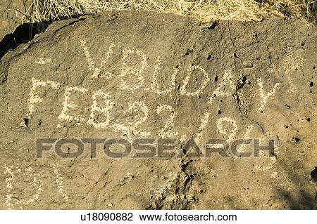 Stock Image - Inscription on rock at Petroglyph National Monument reads, "February 22, 1919" demonstrating vandalism of Native American petroglyphs, outside Albuquerque, New Mexico. Fotosearch