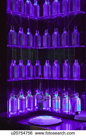Stock Photograph - Multiple Gin bottles in purple light decorate shelves in bar in Barcelona, Spain. Fotosearch