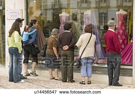 People look at women's dresses in store window in village center of Tomar, Portugal View Large Photo Image Stock Photo - People look at women's dresses in store window in village center of Tomar, Portugal. Fotosearch