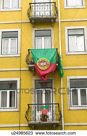 Stock Image - Portuguese flag is displayed from apartment balcony in Lisboa, Lisbon, Portugal, in support of World Cup Soccer. Fotosearch