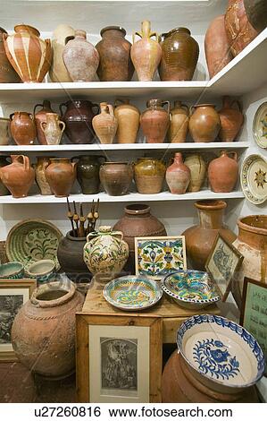 Stock Photograph - Pottery store shows stacks of old pots in old part of Centro, Sevilla Spain. Fotosearch