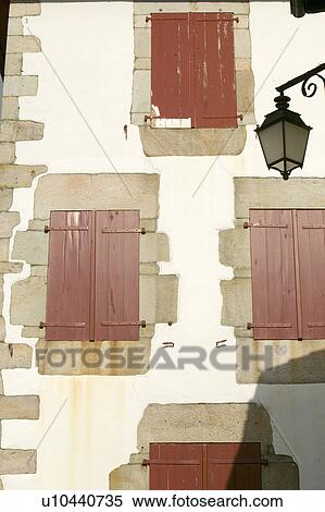 Stock Photography - Red shutter windows of Sare, France in Basque Country on Spanish-French border, a hilltop 17th century village surrounded by farm fields, in the Labourd province. Close to St. Jean de Luz, on the Cote Basque, France.. Fotosearch
