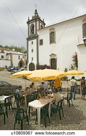 Stock Photo - Restaurant with yellow umbrellas in the village of Obidos founded by the Celts in 300 BC, Portugal. Fotosearch