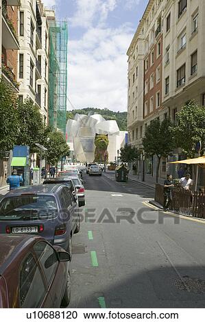 Stock Image - Road leads to The Guggenheim Museum of Contemporary Art of Bilbao (Bilbo), located on the North Coast of Spain in the Basque region. Nicknamed "The Hole", this is a contemporary museum built of titanium, limestone and glass and was designed by Canadian ci. Fotosearch
