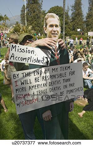 Stock Photo - A man puts his hands around a cutout of George W. Bush saying "Mission Accomplished" at an anti-Iraq War protest march in Santa Barbara, California on March 17, 2007. Fotosearch