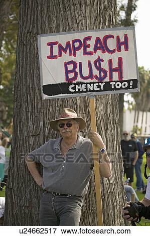 Stock Photo - A protester holds a sign reading "Impeach Bush" at an anti-Iraq War protest march in Santa Barbara, California on March 17, 2007. Fotosearch