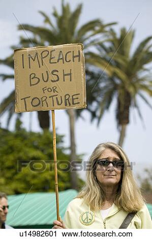 Stock Image - A woman holds a sign saying "Impeach Bush for torture" at an anti-Iraq War protest march in Santa Barbara, California on March 17, 2007. Fotosearch