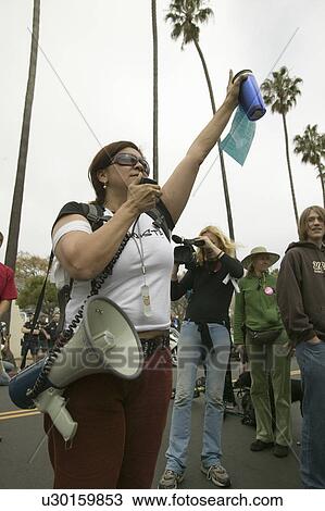 Stock Image - A woman protester with a loud speaker gestures with her arm to the crowd at an anti-Iraq War protest march in Santa Barbara, California on March 17, 2007. Fotosearch