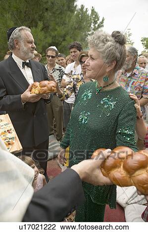 Bride, groom and guests break bread at a traditional Jewish wedding in Ojai, CA View Large Photo Image Stock Image - Bride, groom and guests break bread at a traditional Jewish wedding in Ojai, CA. Fotosearch