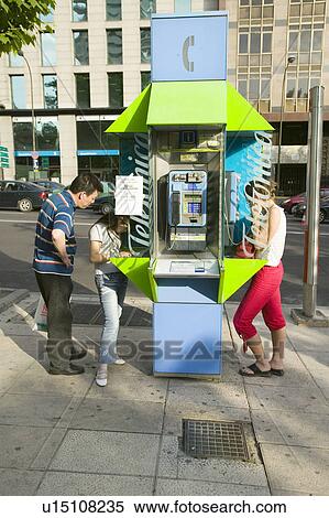 Bright green telephone booth being used on the summer sidewalks of Madrid, Spain View Large Photo Image Stock Photography - Bright green telephone booth being used on the summer sidewalks of Madrid, Spain. Fotosearch
