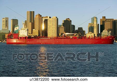 Bright red cargo ship travels in front of Boston Harbor and the Boston skyline at sunrise as seen from South Boston, Massachusetts, New England View Large Photo Image Stock Image - Bright red cargo ship travels in front of Boston Harbor and the Boston skyline at sunrise as seen from South Boston, Massachusetts, New England. Fotosearch