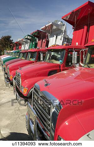 Bright red Mack dump trucks line the road in a row, in Maine near the New Hampshire border View Large Photo Image Stock Image - Bright red Mack dump trucks line the road in a row, in Maine near the New Hampshire border. Fotosearch