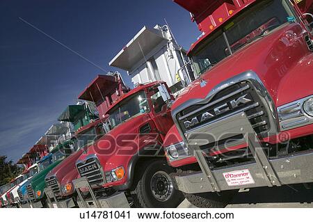 Bright red Mack dump trucks line the road in a row, in Maine near the New Hampshire border View Large Photo Image Stock Image - Bright red Mack dump trucks line the road in a row, in Maine near the New Hampshire border. Fotosearch