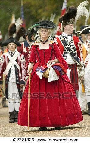Stock Photograph - British lady in red dress watches with disdain the British surrender to General George Washington at the 225th Anniversary of the Victory at Yorktown, a reenactment of the siege of Yorktown, where General George Washington commanded 17, 600 American troops. Fotosearch